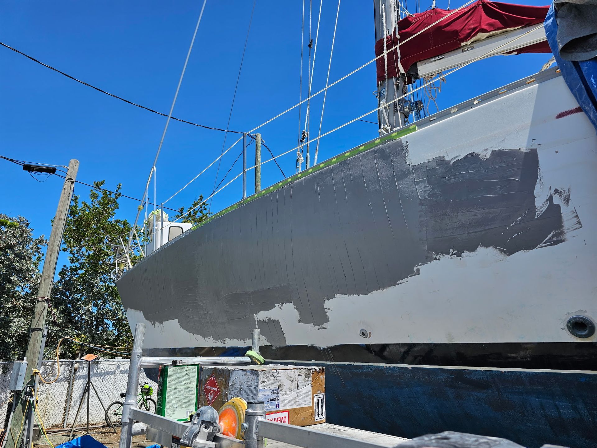 A boat is being painted on a sunny day