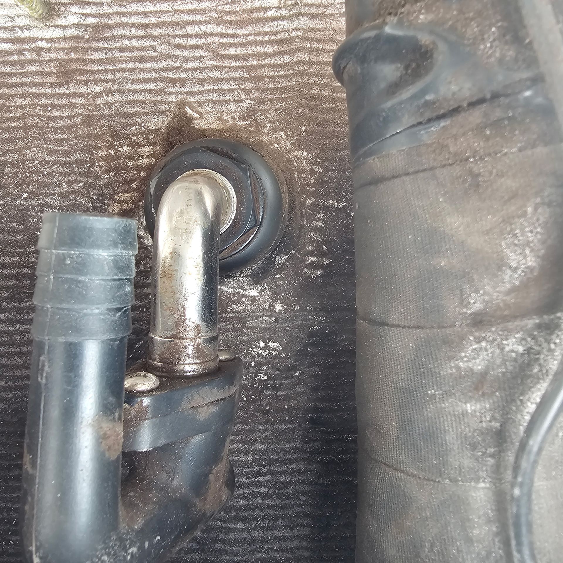 A close up of a pipe with a hose attached to it