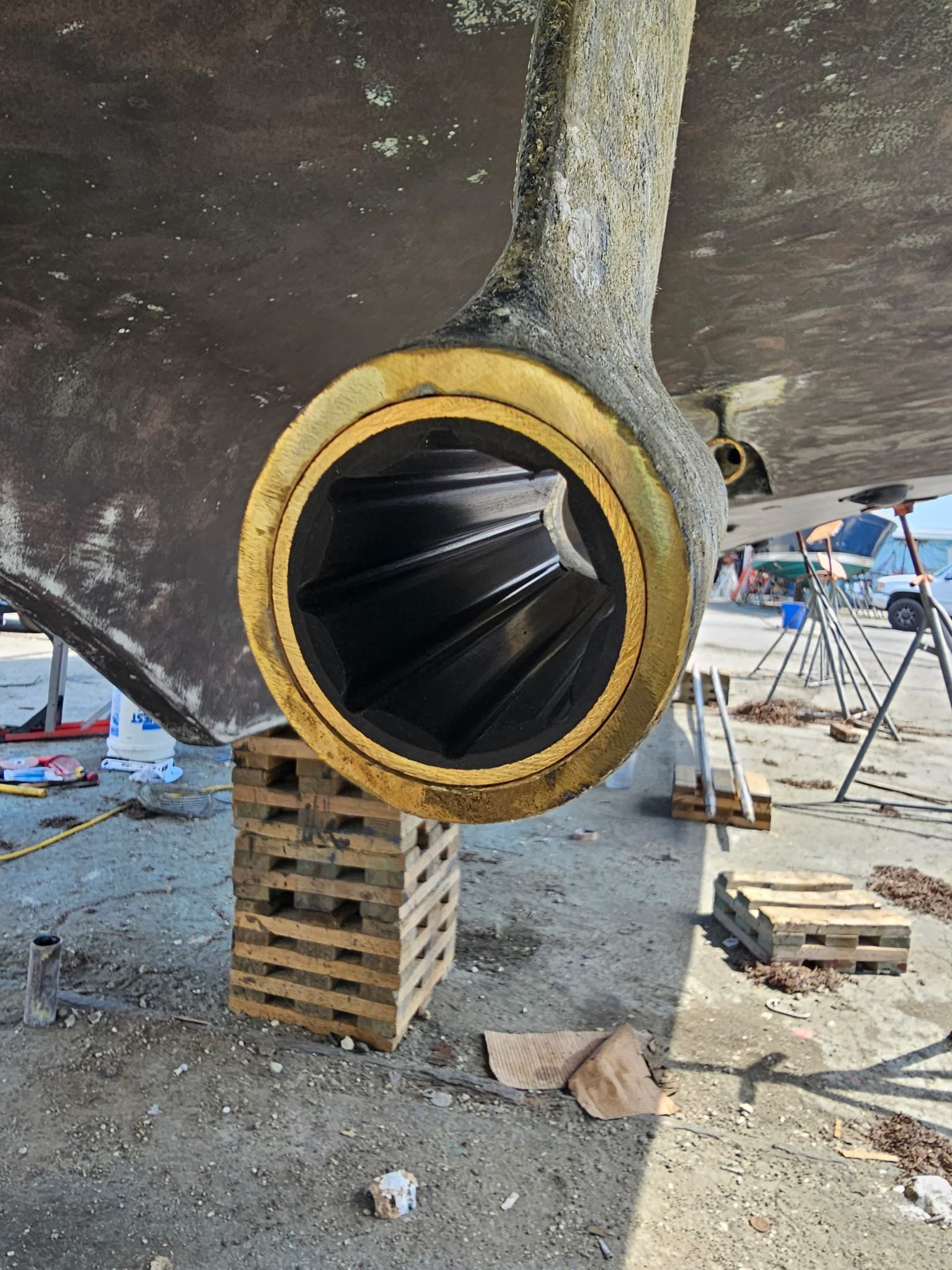 A boat propeller is sitting on top of a wooden pallet.
