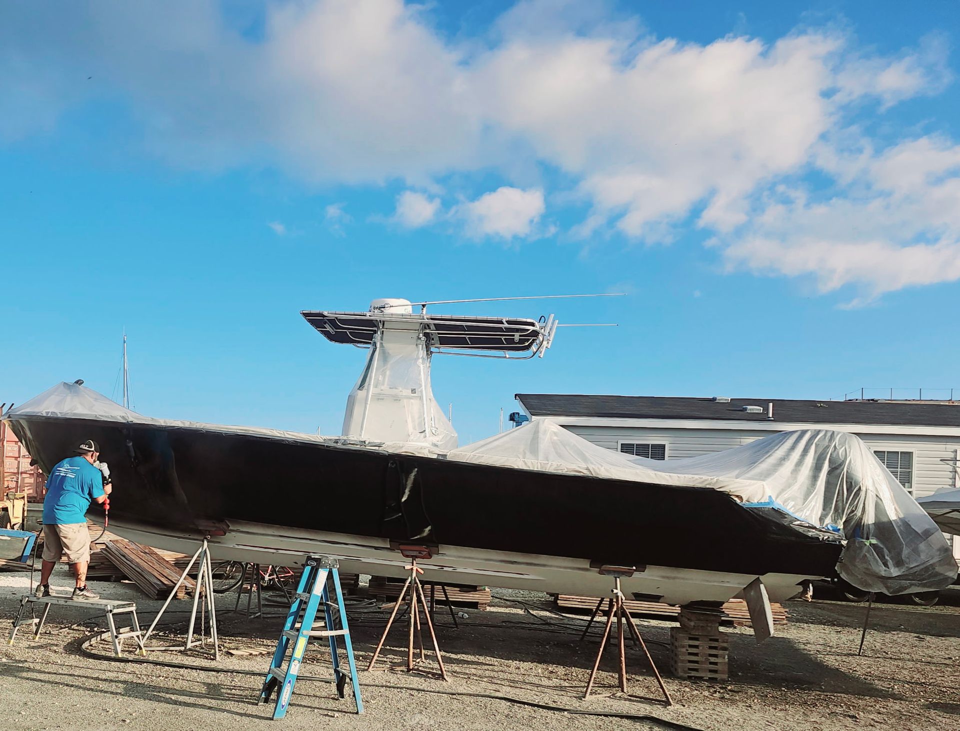 A plane is being painted in a field with a blue sky in the background