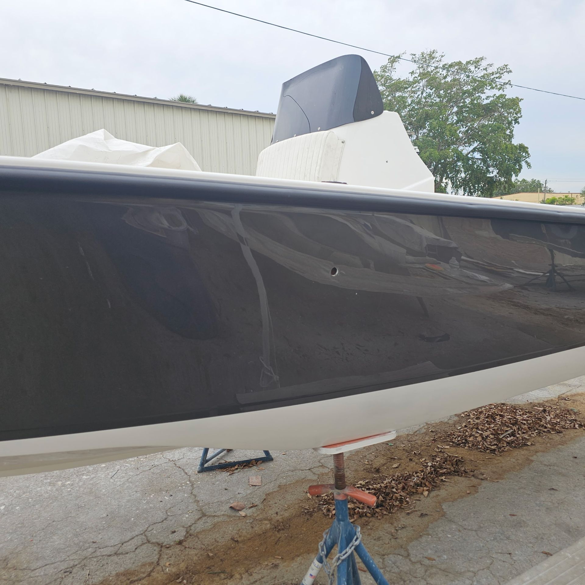 A boat is sitting on a stand in a parking lot