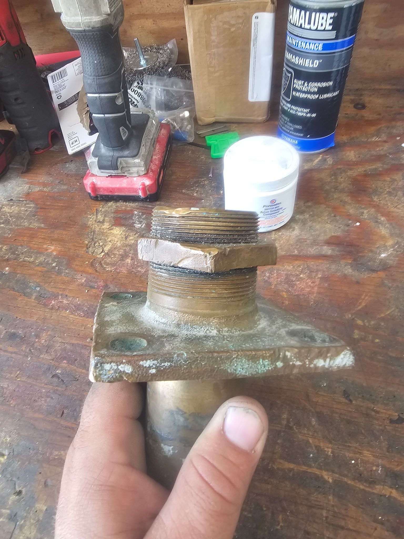 A person is holding a piece of brass in their hand.