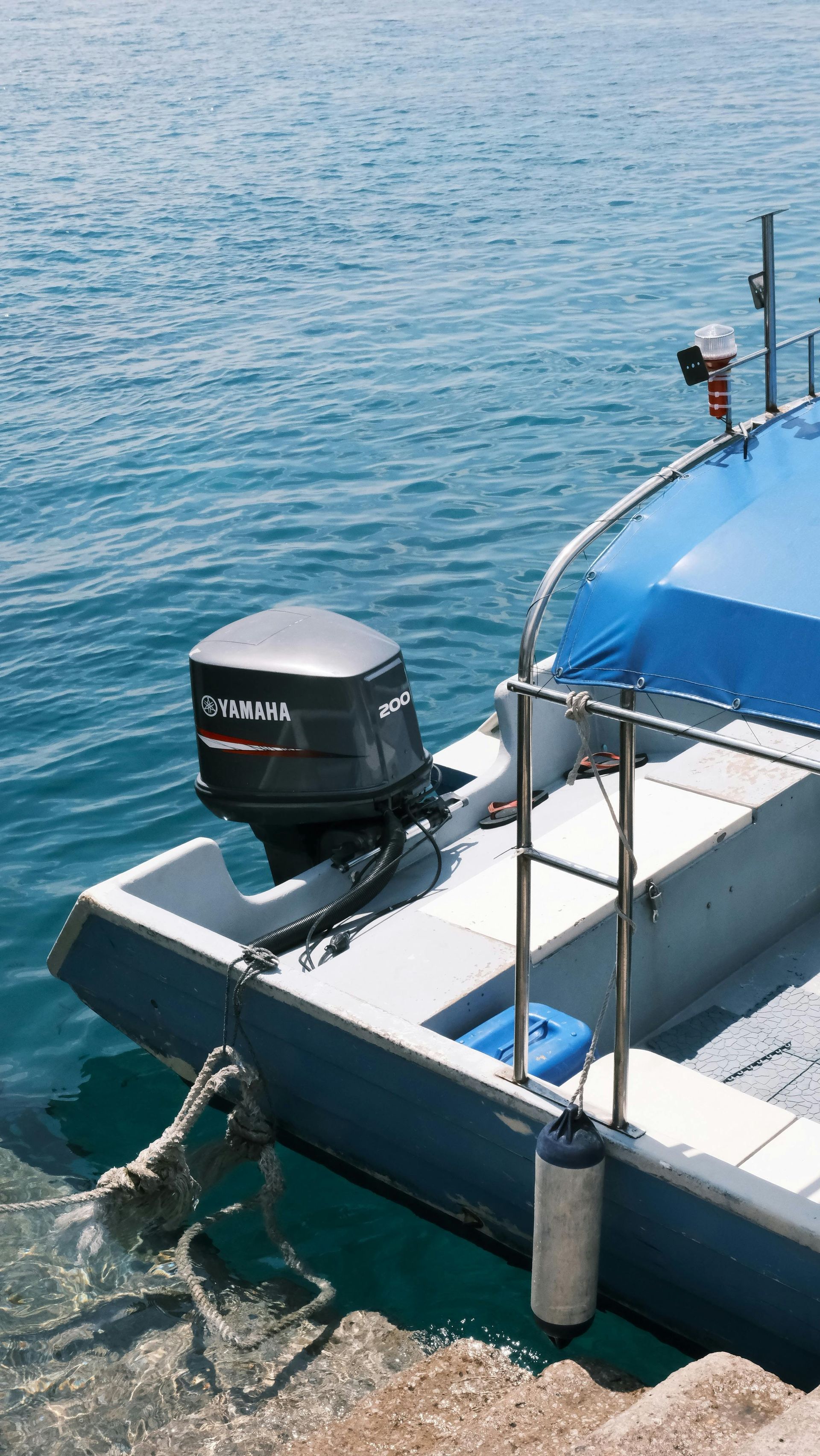 A small boat with a motor attached to it is docked in the water.