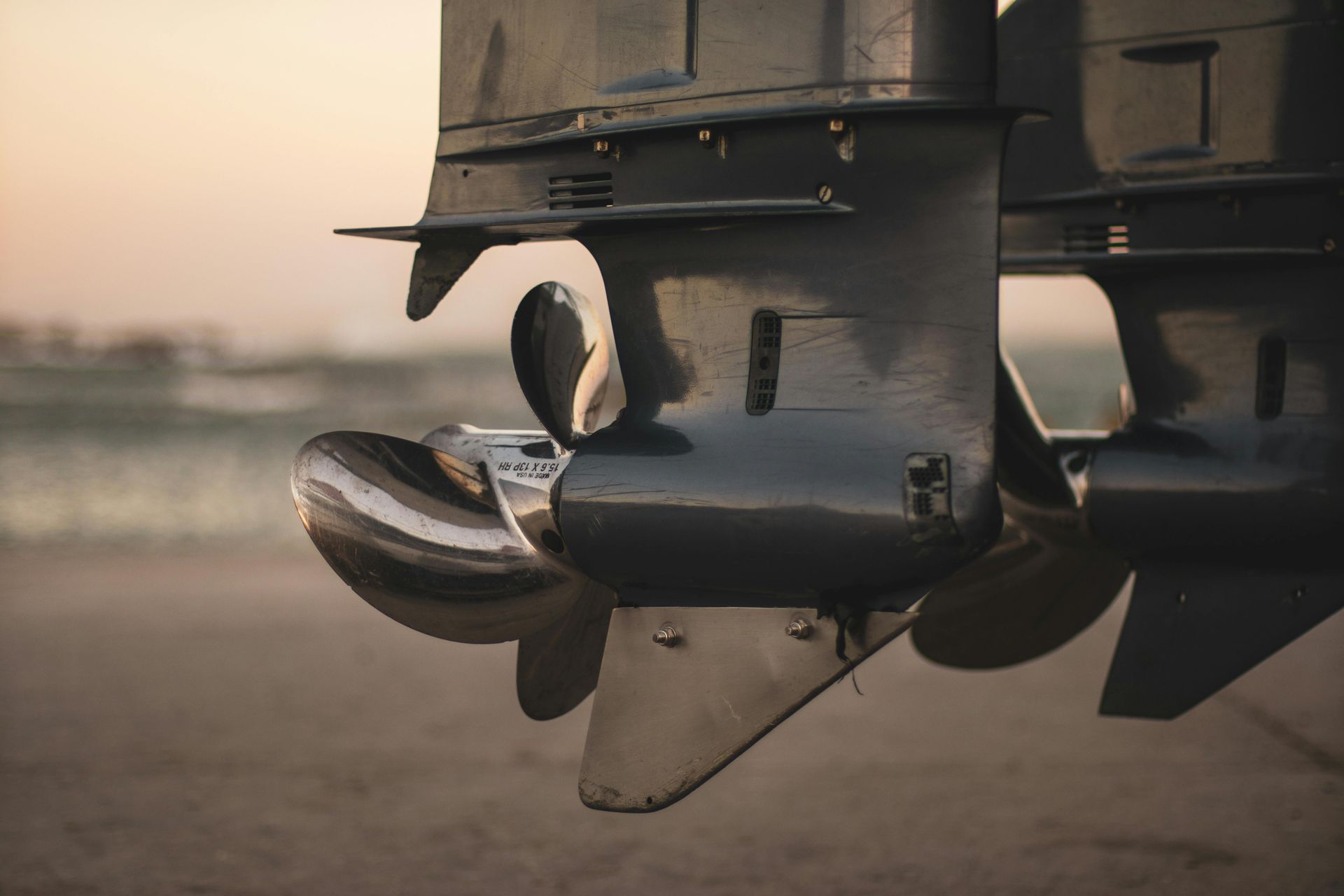 A close up of a boat engine on the beach.