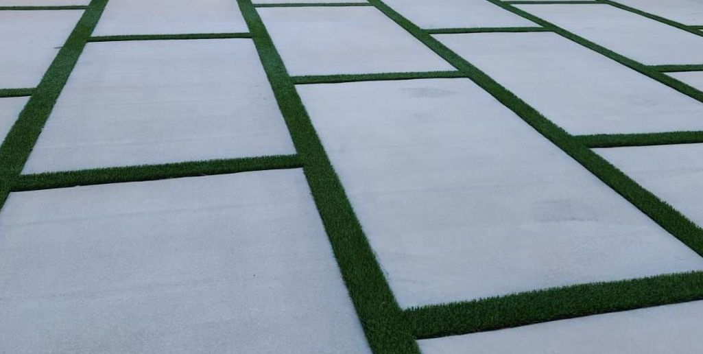 artificial turf strips installed between concrete pavers by Miami Asphalt Paving and Sealcoating contractors