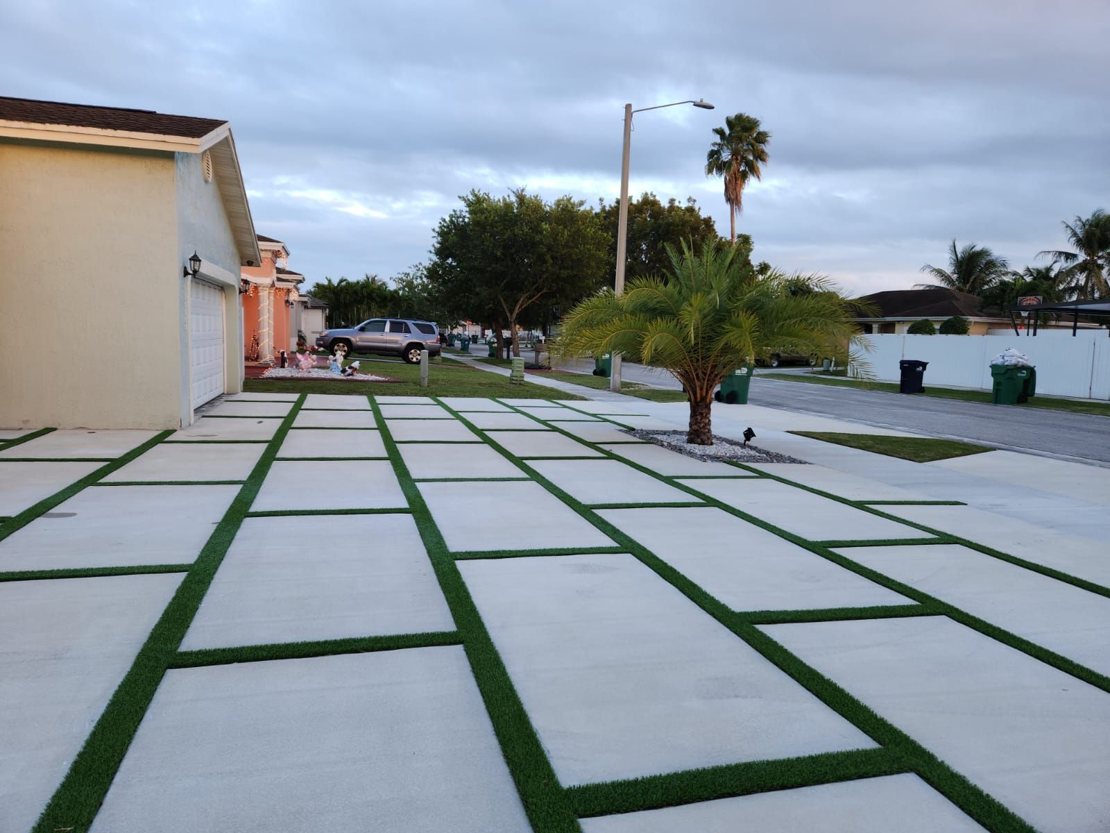 synthetic grass strips are installed between the concrete pavers to define them