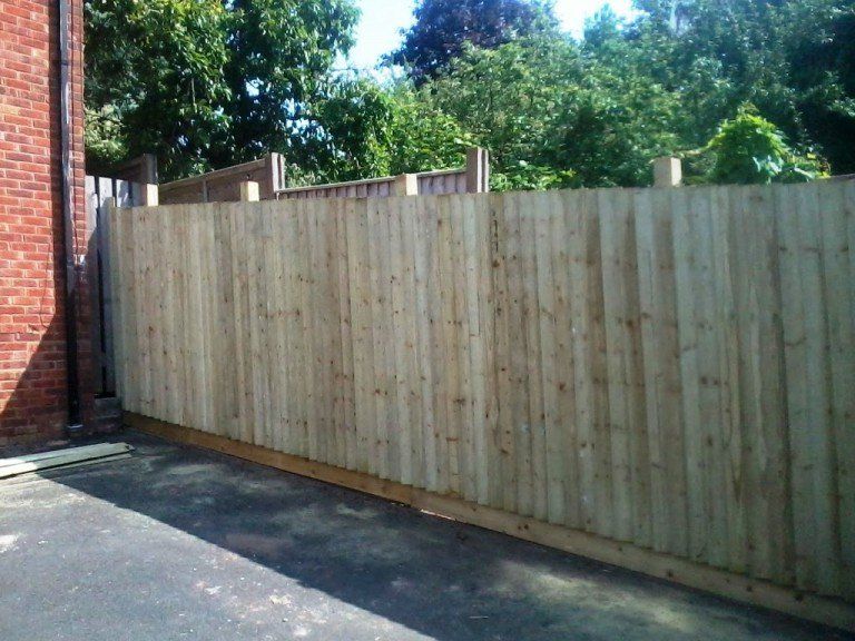 A wooden fence with a brick building in the background