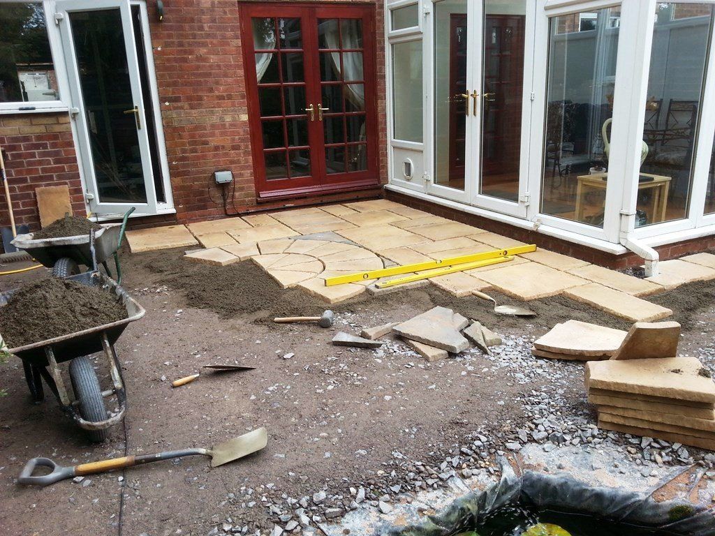 A wheelbarrow filled with dirt is sitting in front of a house.