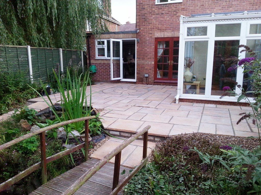 There is a bridge in the middle of the garden leading to the house.