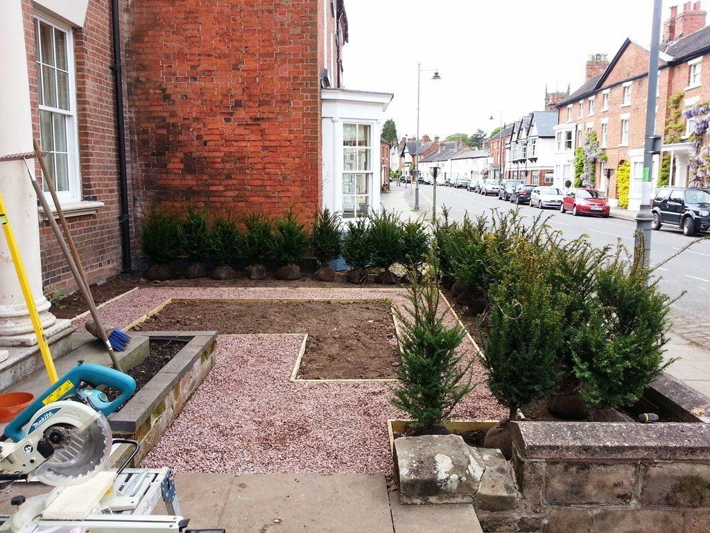A circular saw is sitting on the sidewalk in front of a brick building.