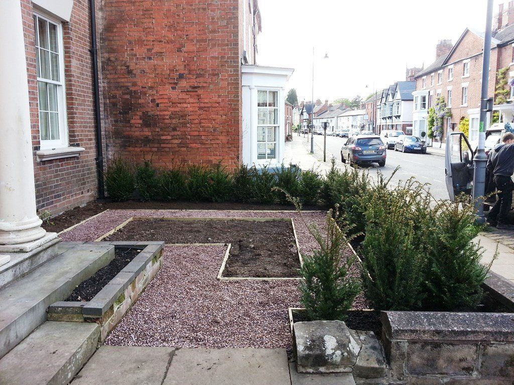 A brick building with a garden in front of it