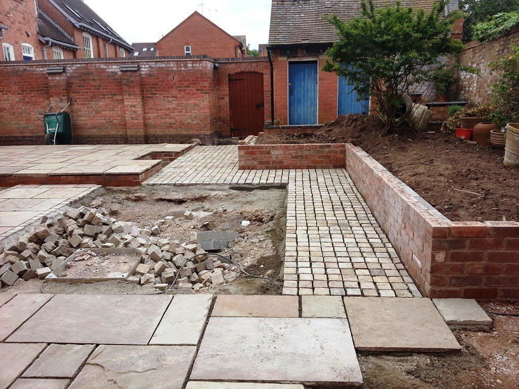 A brick wall is being built in a backyard