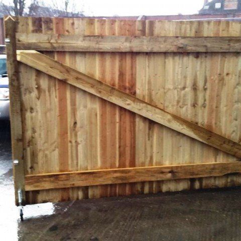 A wooden fence with a car parked behind it