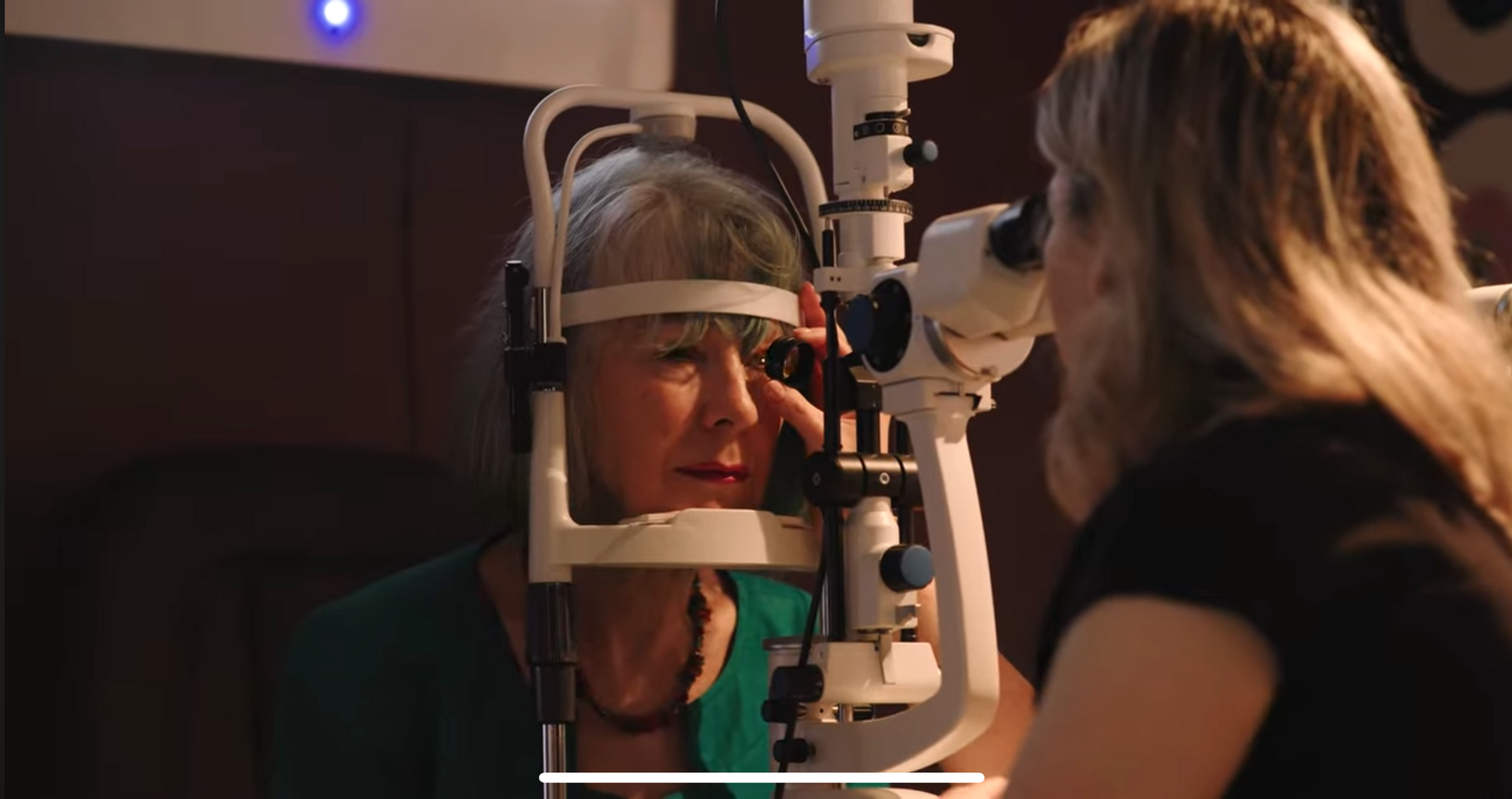 An optometrist carrying out an eye exam in a modern test room