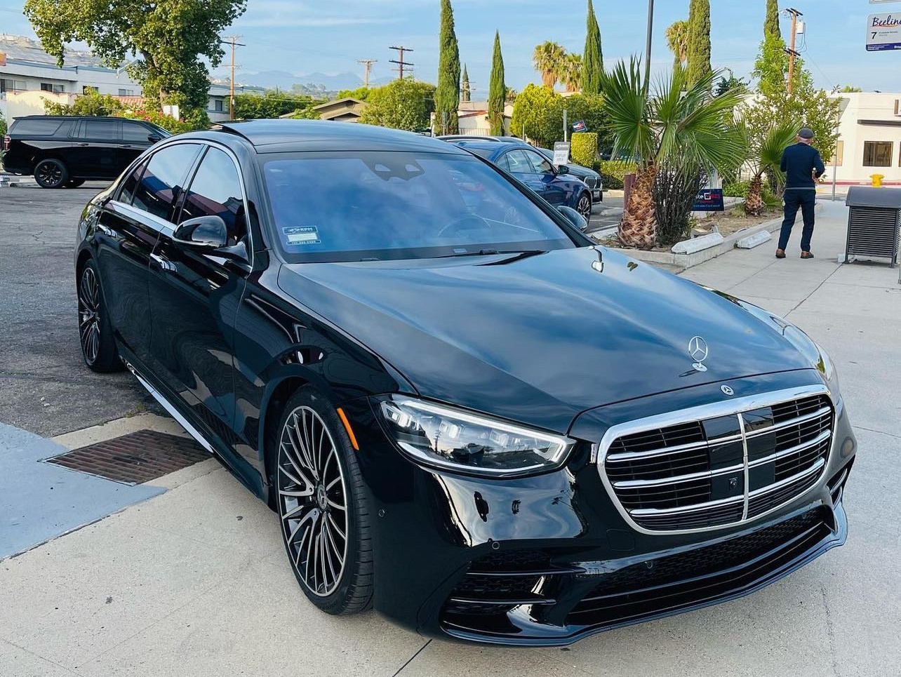 a black mercedes benz s class is parked in a parking lot .