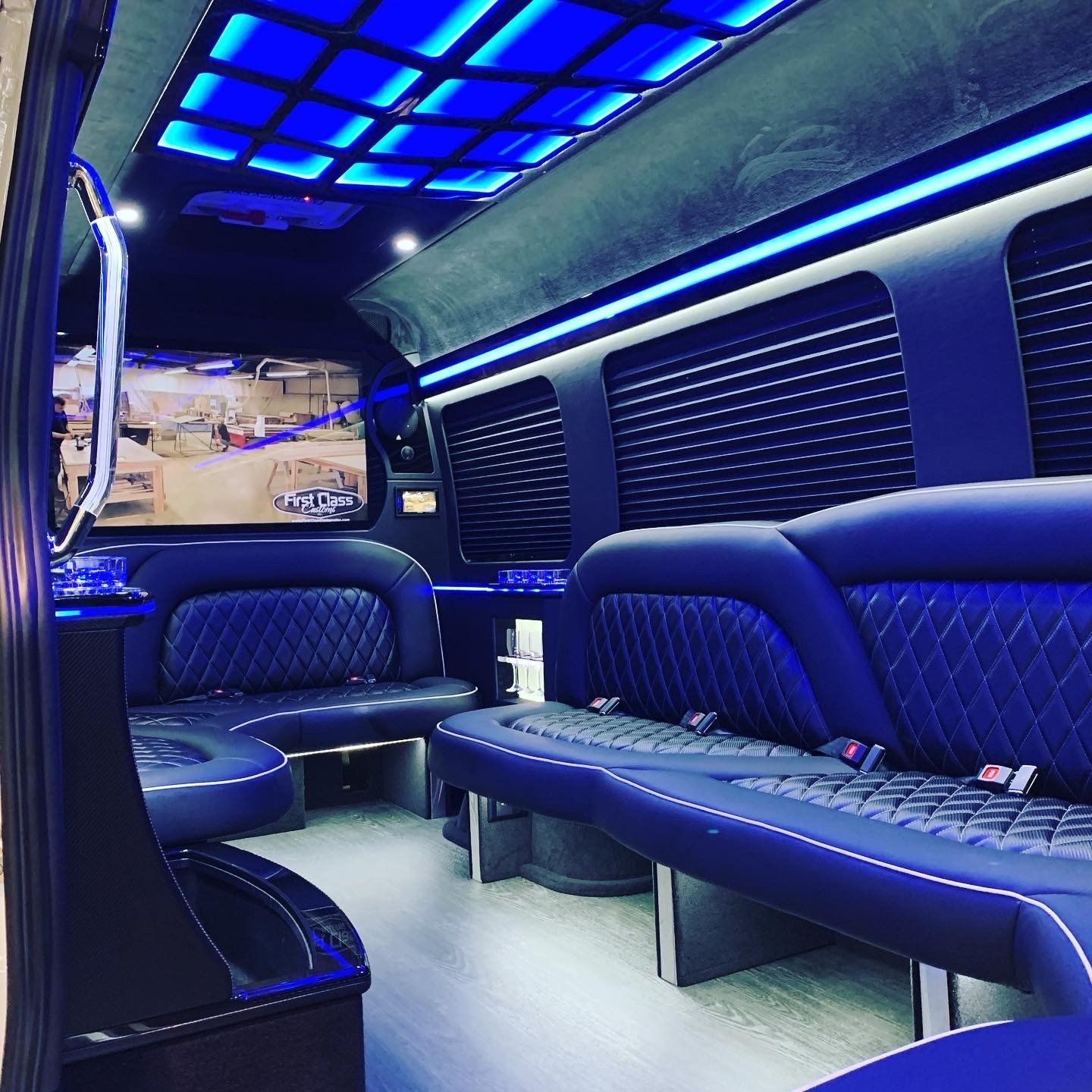the inside of a van with blue seats and a television .