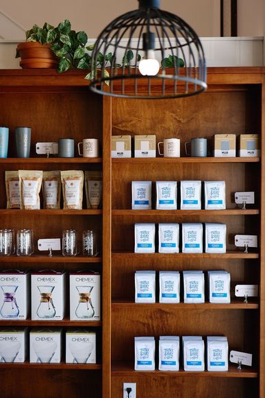 Shelf of Three Story Coffee Merch & Products Like Premium Coffee Beans & Cocoa Powder