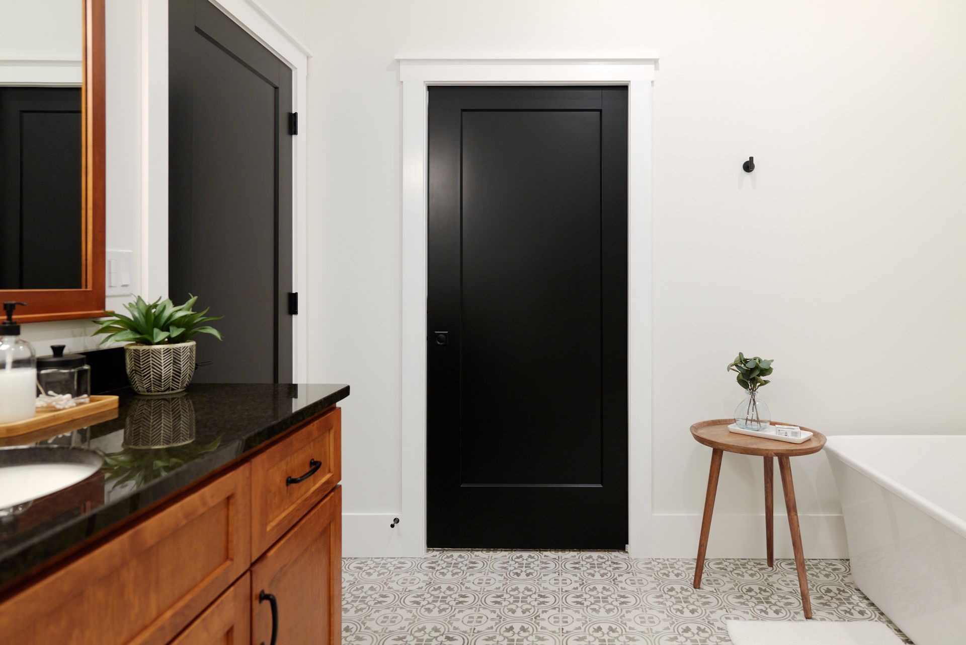 A Sleek Bathroom With a Black Door at Three Story Coffee's Short-Term Rental Space in Mid-MO.