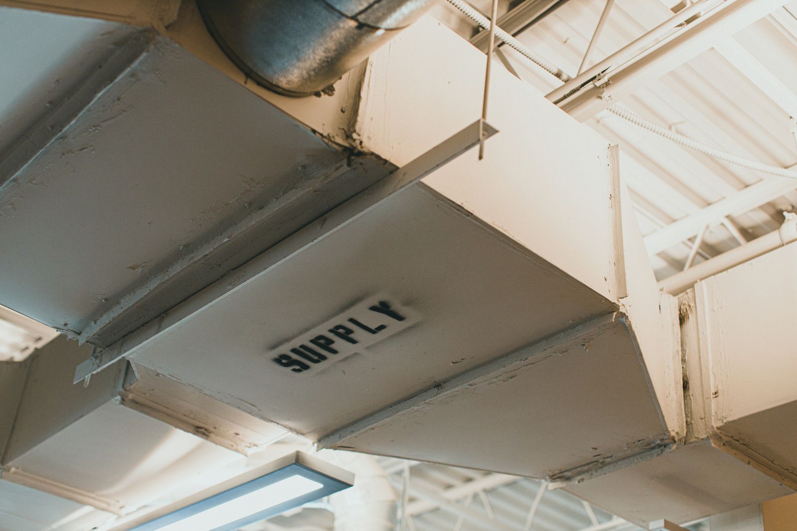 A supply box is hanging from the ceiling of a building.