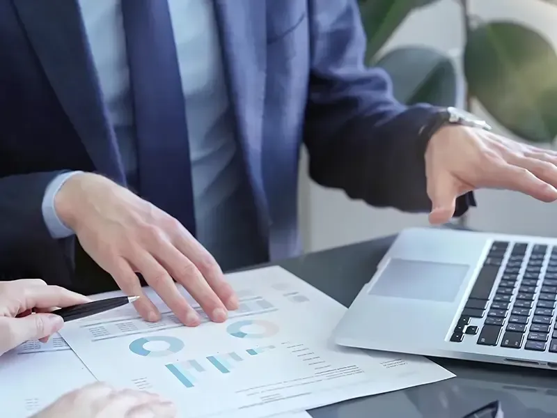 Un hombre con traje está sentado en un escritorio utilizando una computadora portátil.