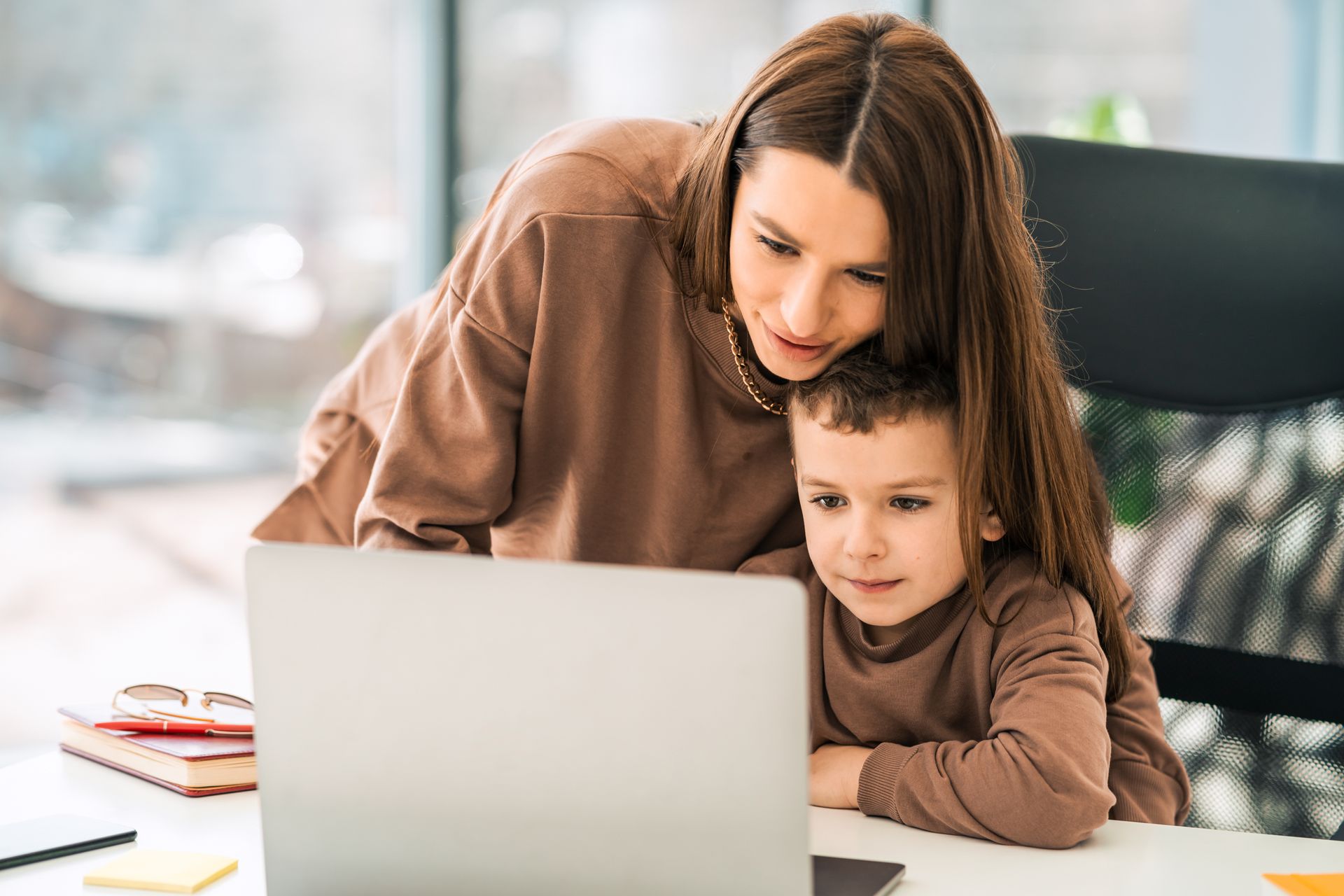 mother and son on the computer at home for a virtual medical visit