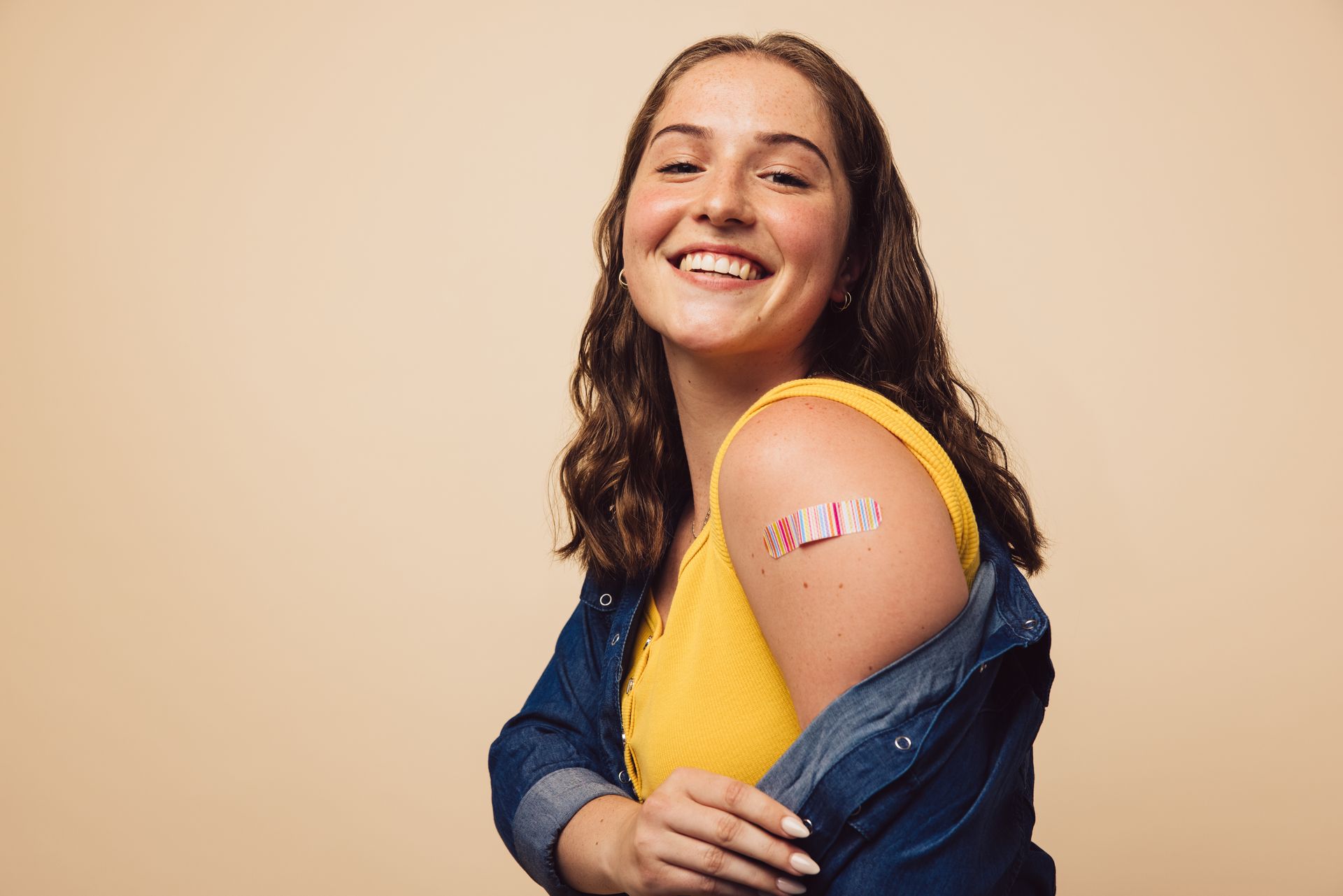 teen smiling after receiving vaccine in arm