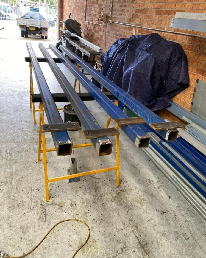 A Bunch of Metal Pieces Are Sitting on A Table — Optimum Aluminium Fabrication in Barrack Heights, NSW
