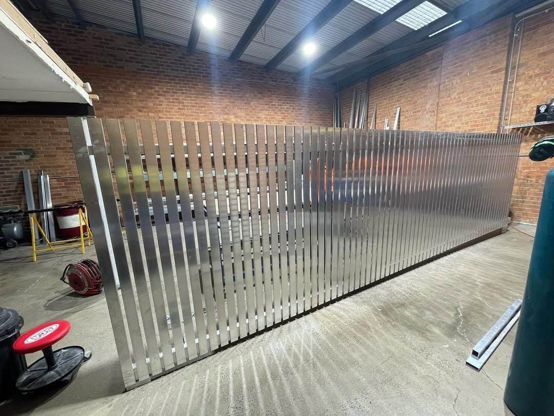 A Stainless Steel Fence Is Being Built in A Warehouse — Optimum Aluminium Fabrication in Barrack Heights, NSW