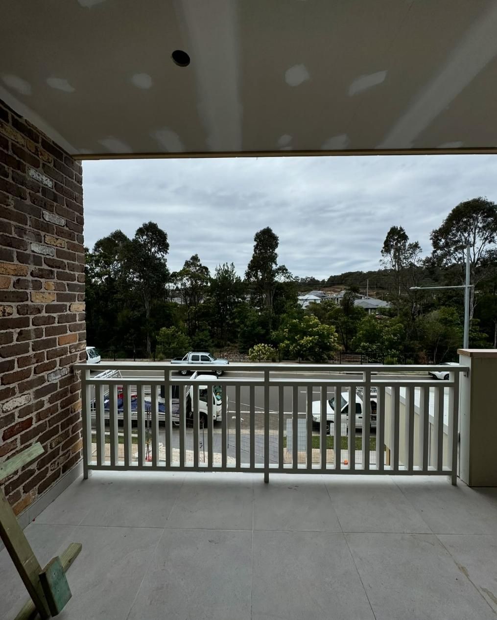 A Balcony with A Brick Wall and A White Railing — Optimum Aluminium Fabrication in Barrack Heights, NSW