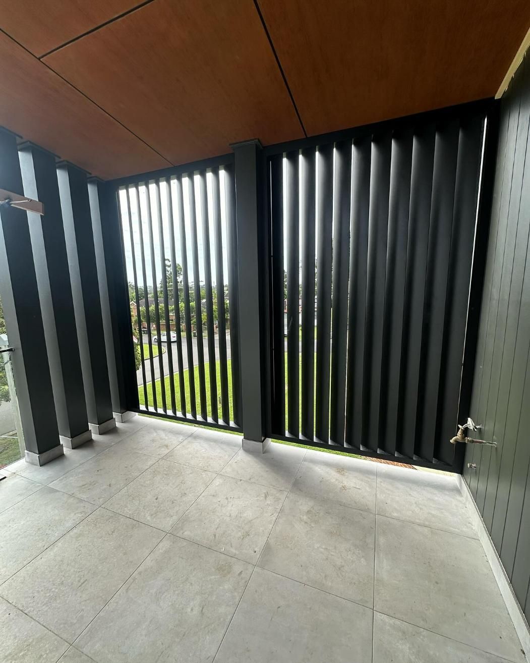 A Balcony with A Black Fence and A Wooden Ceiling — Optimum Aluminium Fabrication in Barrack Heights, NSW