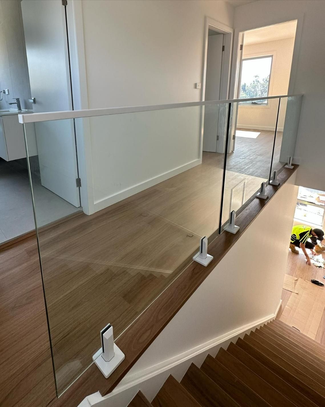 A Staircase with A Glass Railing and A Wooden Floor — Optimum Aluminium Fabrication in Shellharbour, NSW