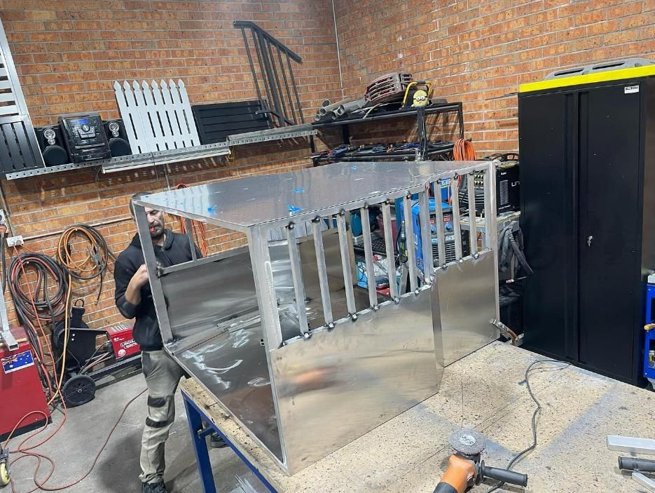 A Man Is Standing Next to A Stainless Steel Box — Optimum Aluminium Fabrication in Barrack Heights, NSW
