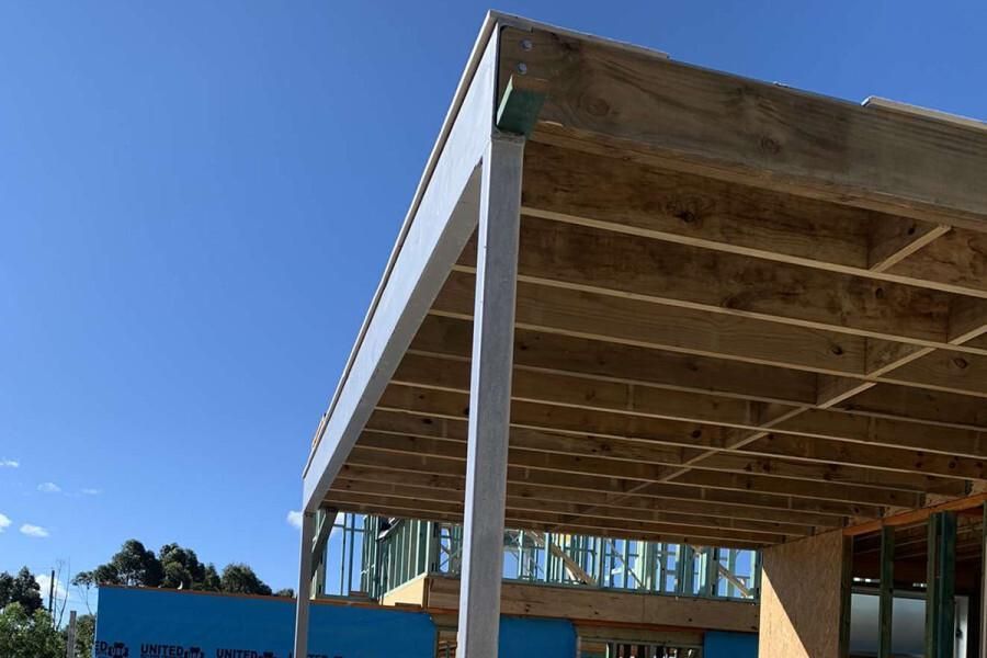 A Wooden Structure Is Being Built with A Blue Sign in The Background — Optimum Aluminium Fabrication in Barrack Heights, NSW