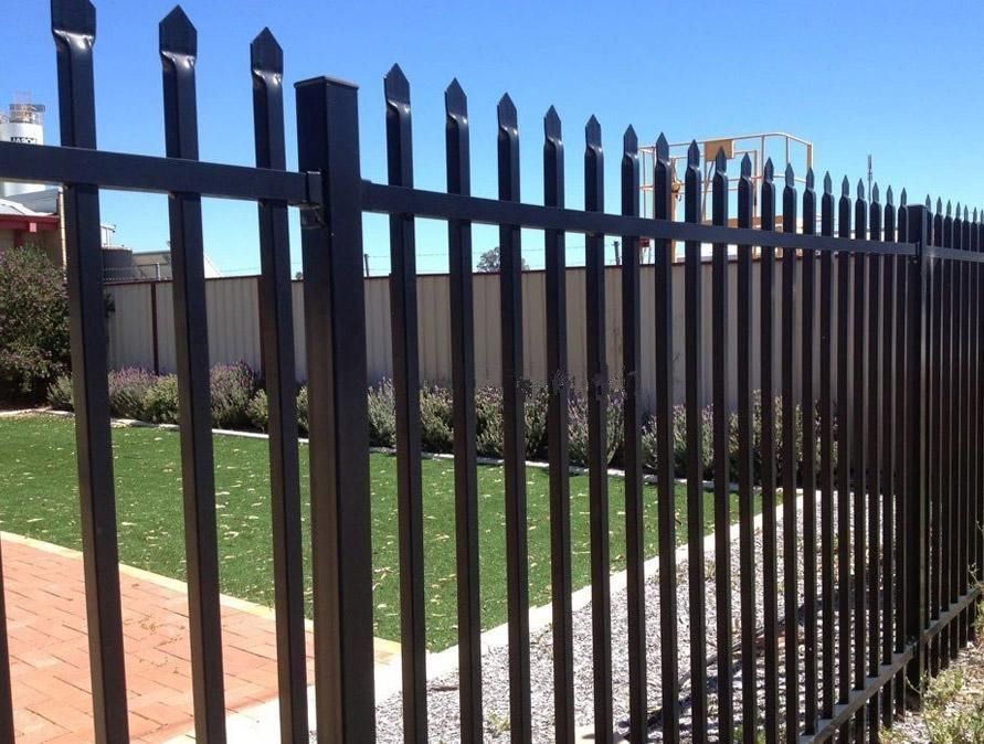 A Black Metal Fence Surrounds a Lush Green Field — Optimum Aluminium Fabrication in Barrack Heights, NSW
