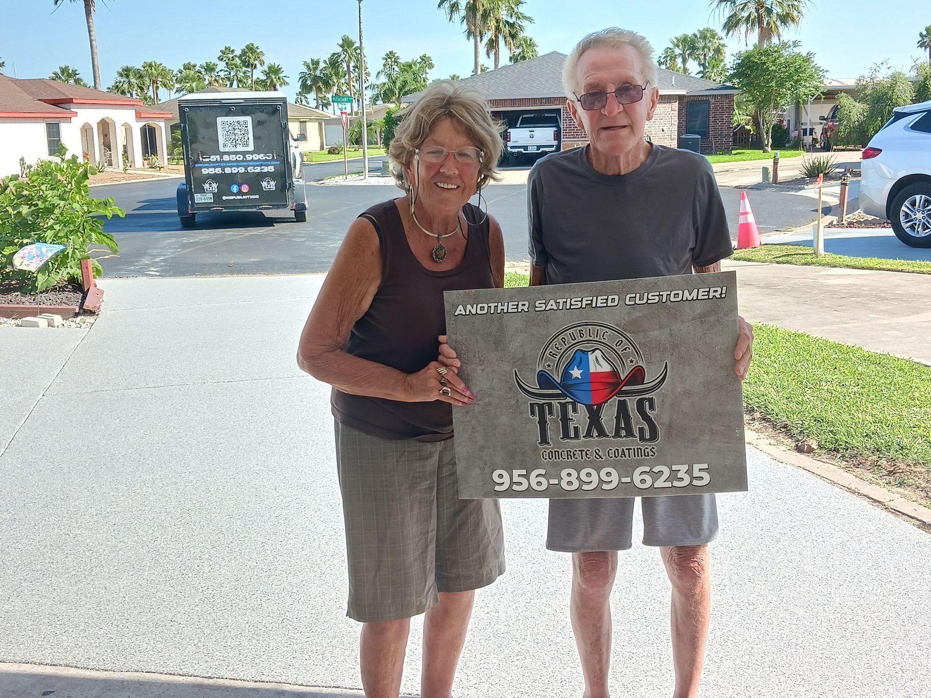 Smiling couple holding a stone sign that reads 