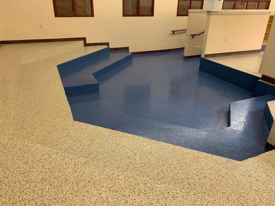 Blue and beige floors with built-in steps. A room with a painted blue section and flecked beige floor.