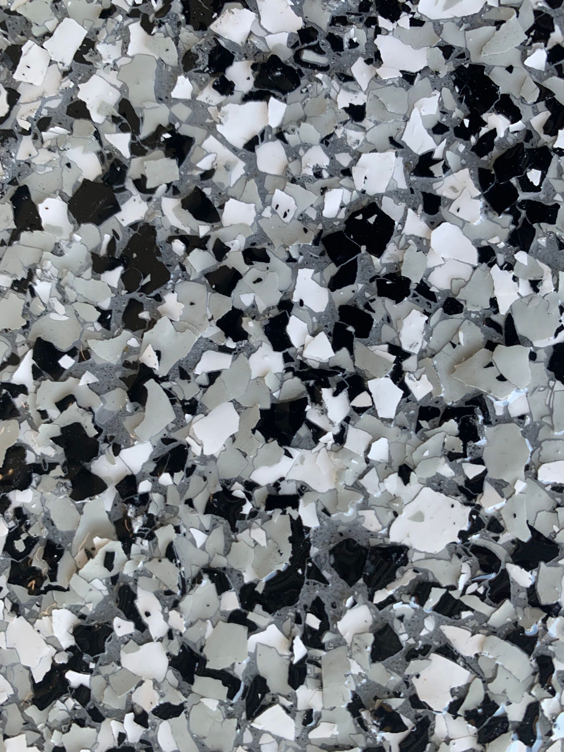 Close-up of a speckled floor coating with black, white, and gray chips.