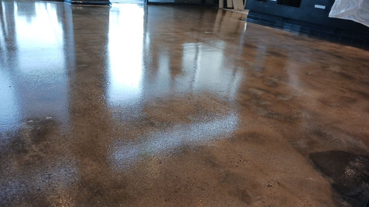 Polished concrete floor reflecting light, brown and gray hues.