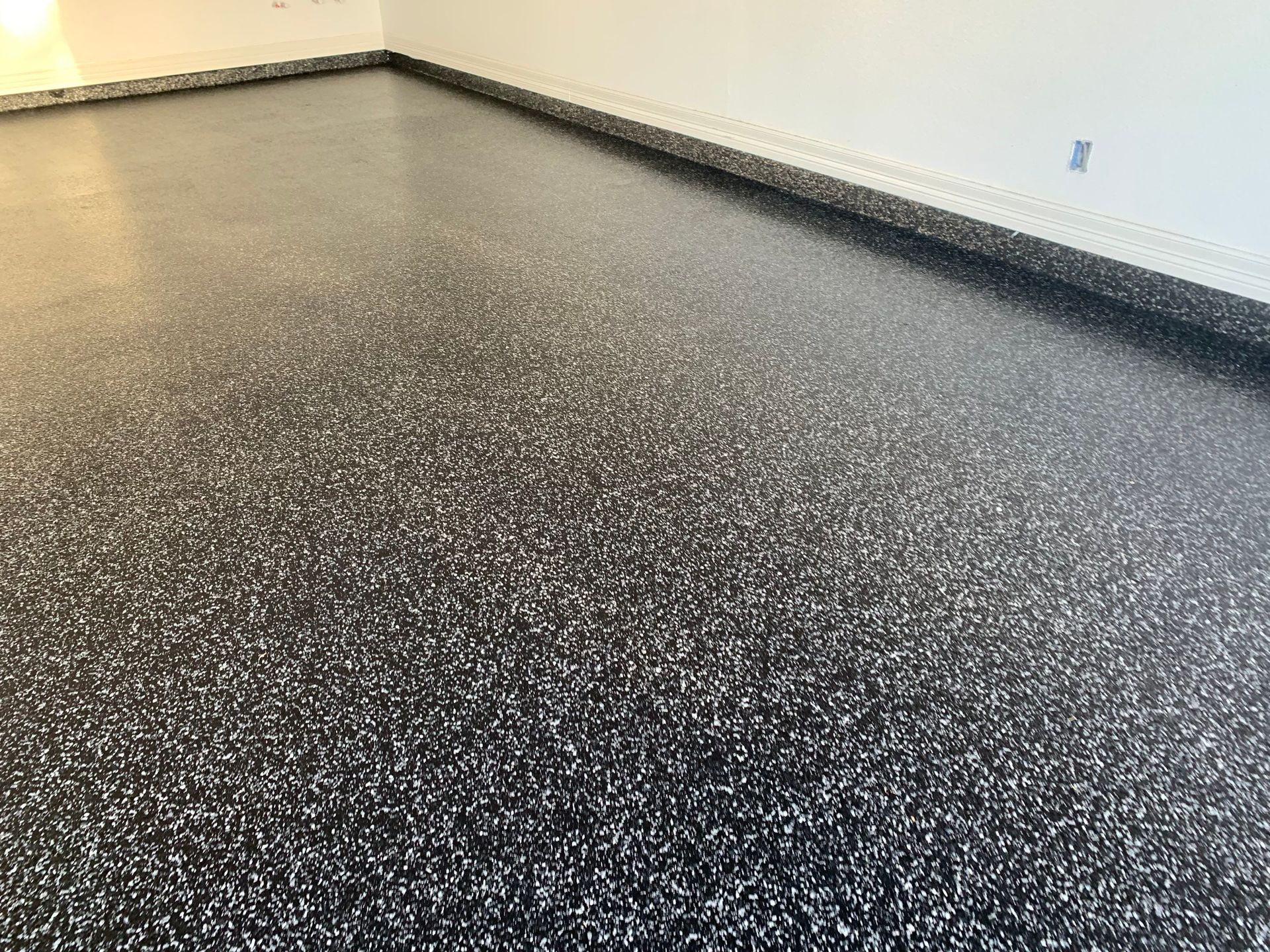 Black and white speckled epoxy garage floor.