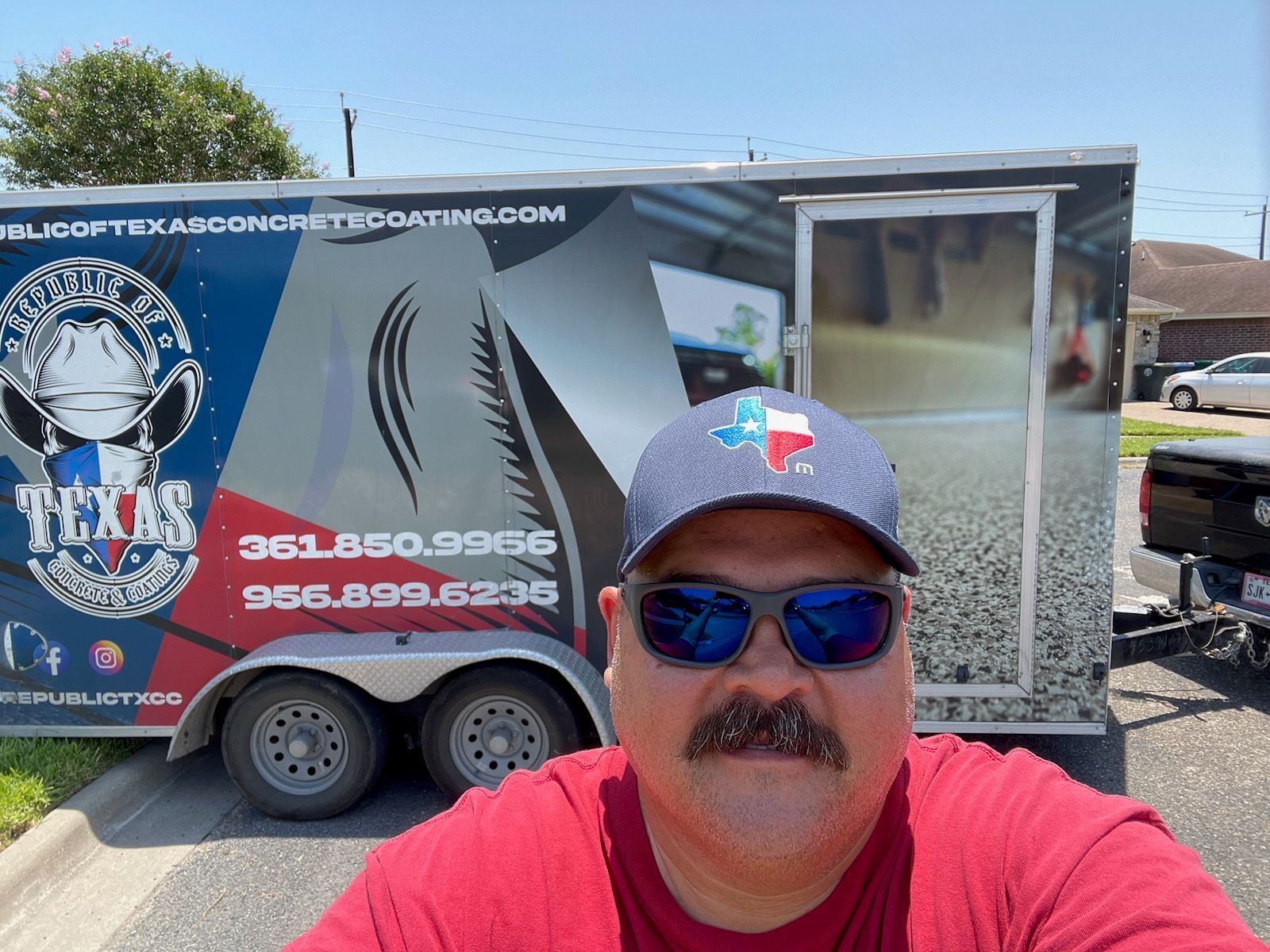 Man in Texas hat with a trailer. The trailer has a Texas logo and phone numbers.
