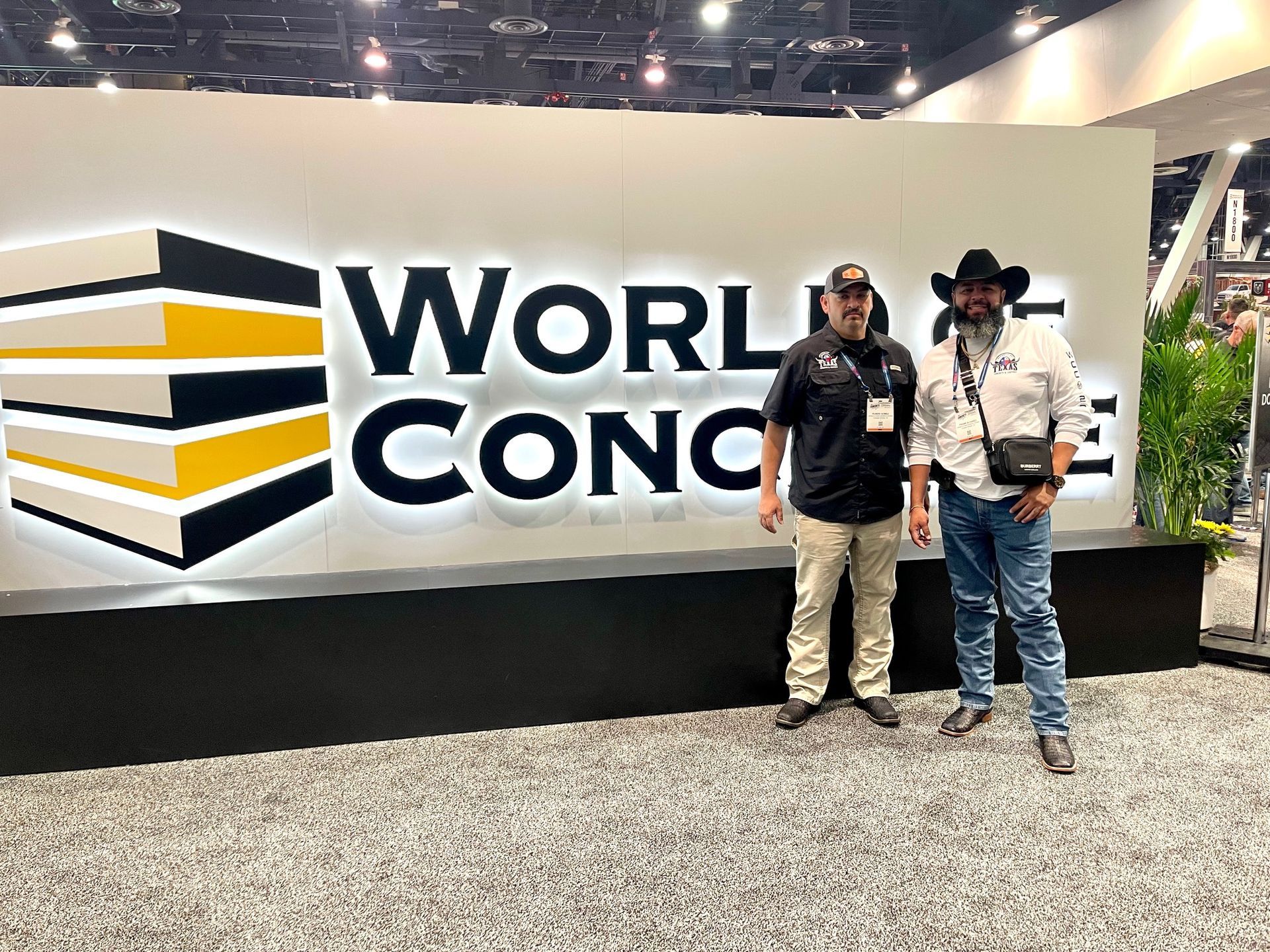 Two men pose in front of a 