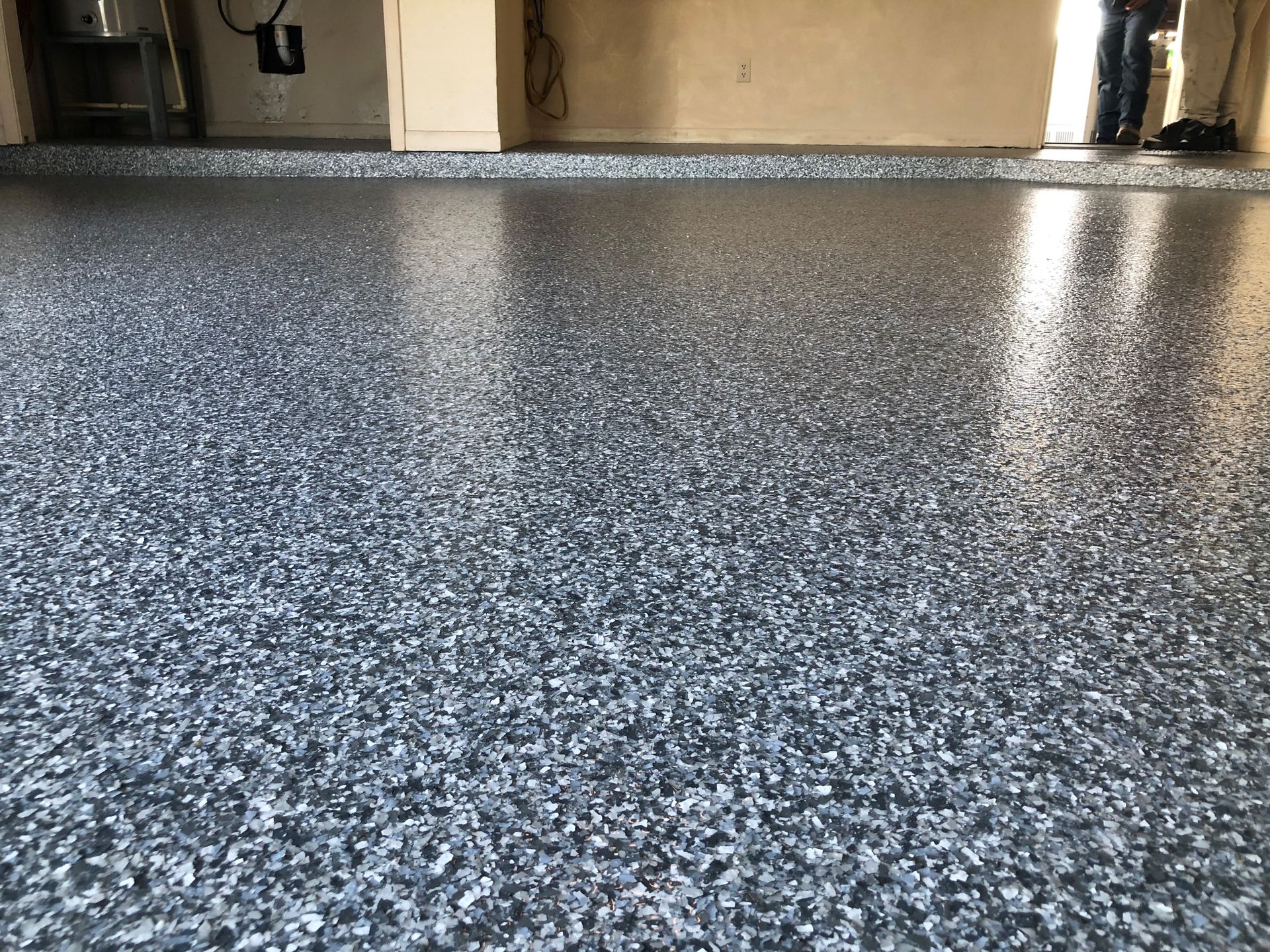 Epoxy garage floor with flecks of blue and gray, reflecting light.