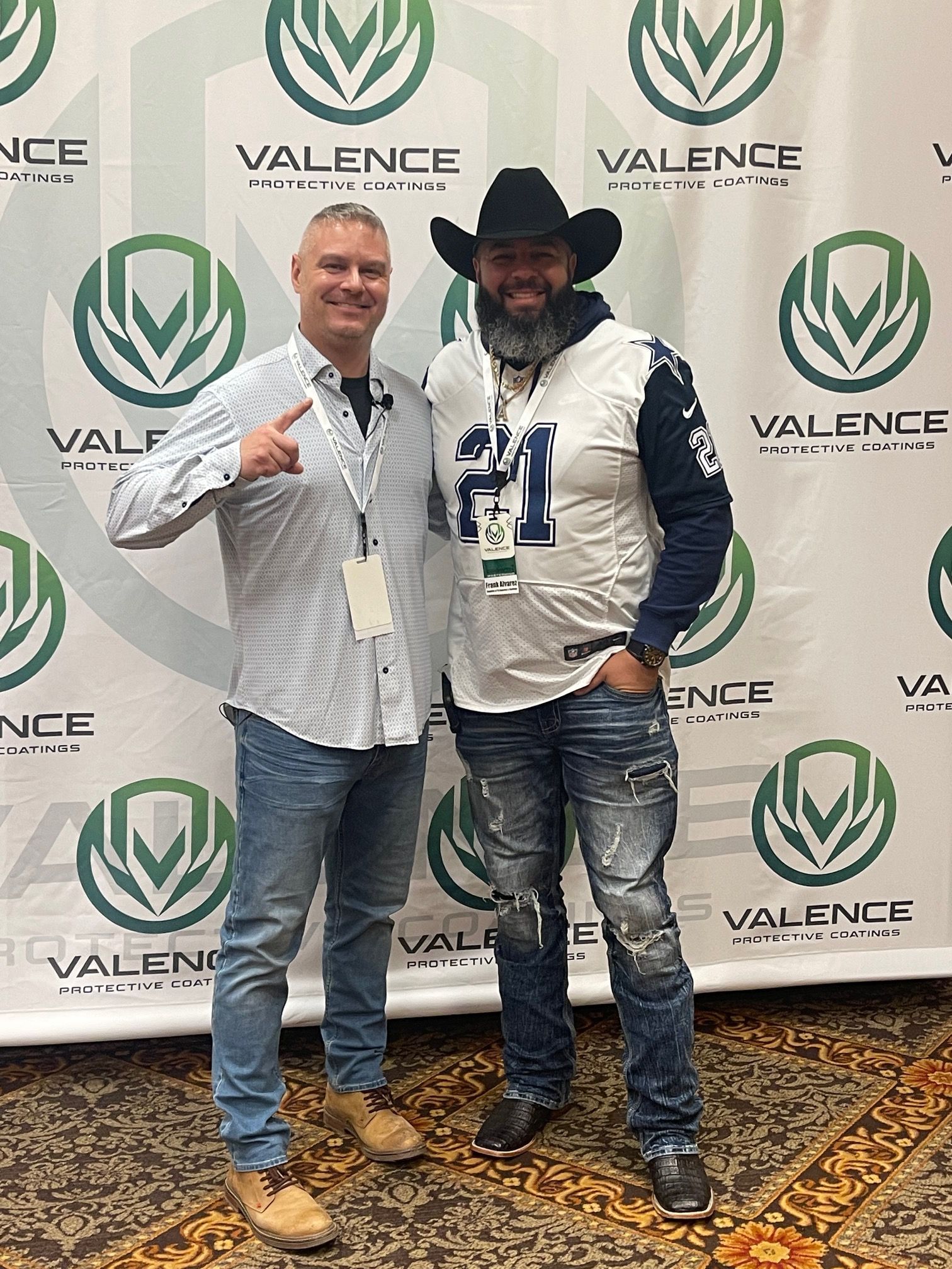 Two men pose in front of a 