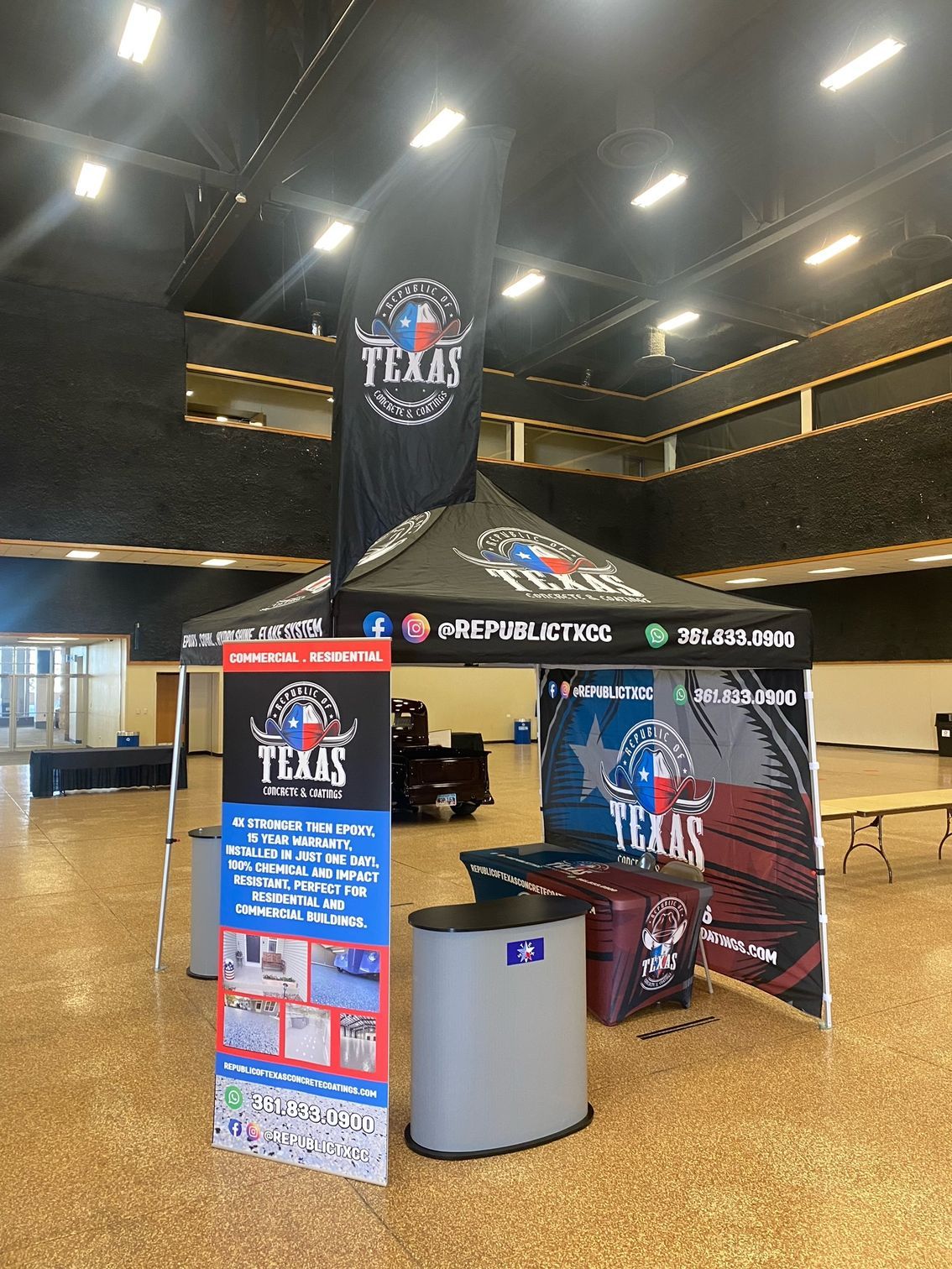 Promotional booth with Texas logo in a large room. Banner, pop-up tent, and display.