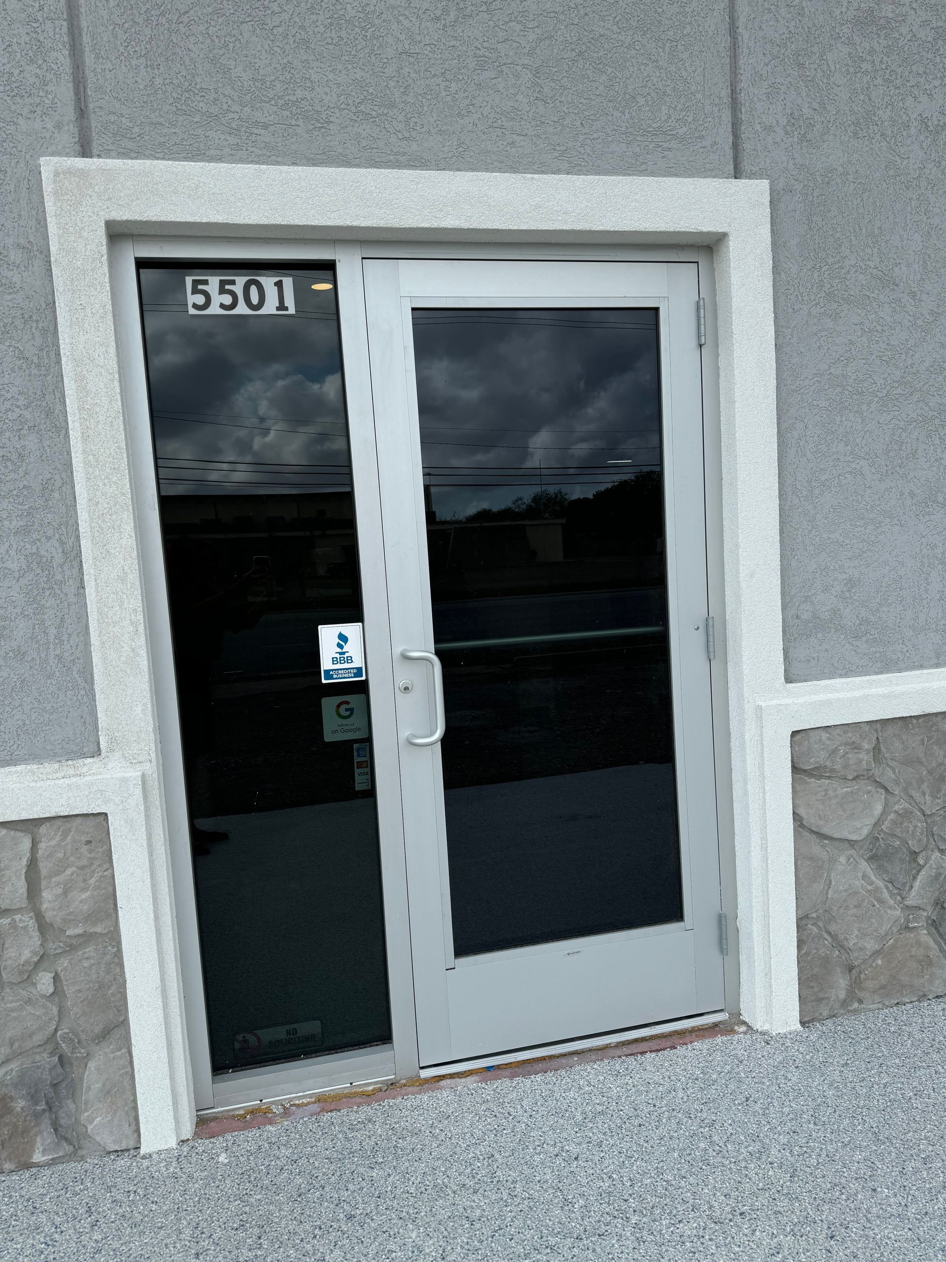 Exterior view of a building entrance with two glass doors. The door on the left has the address 5501.