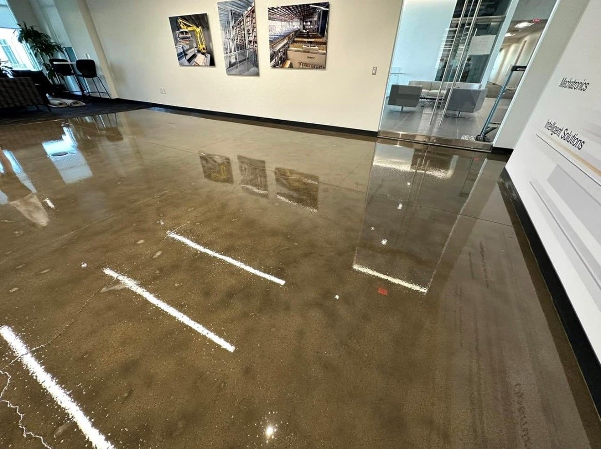 A shiny, dark brown floor with bright reflections, likely in a lobby or office.