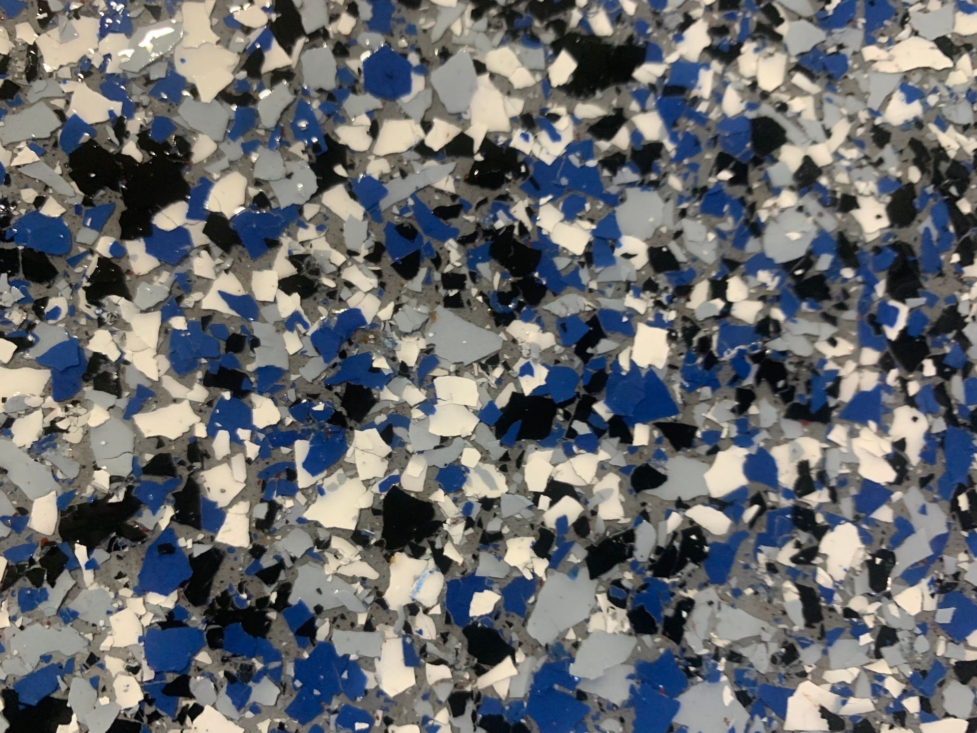 Blue, black, gray, and white flecked epoxy floor.