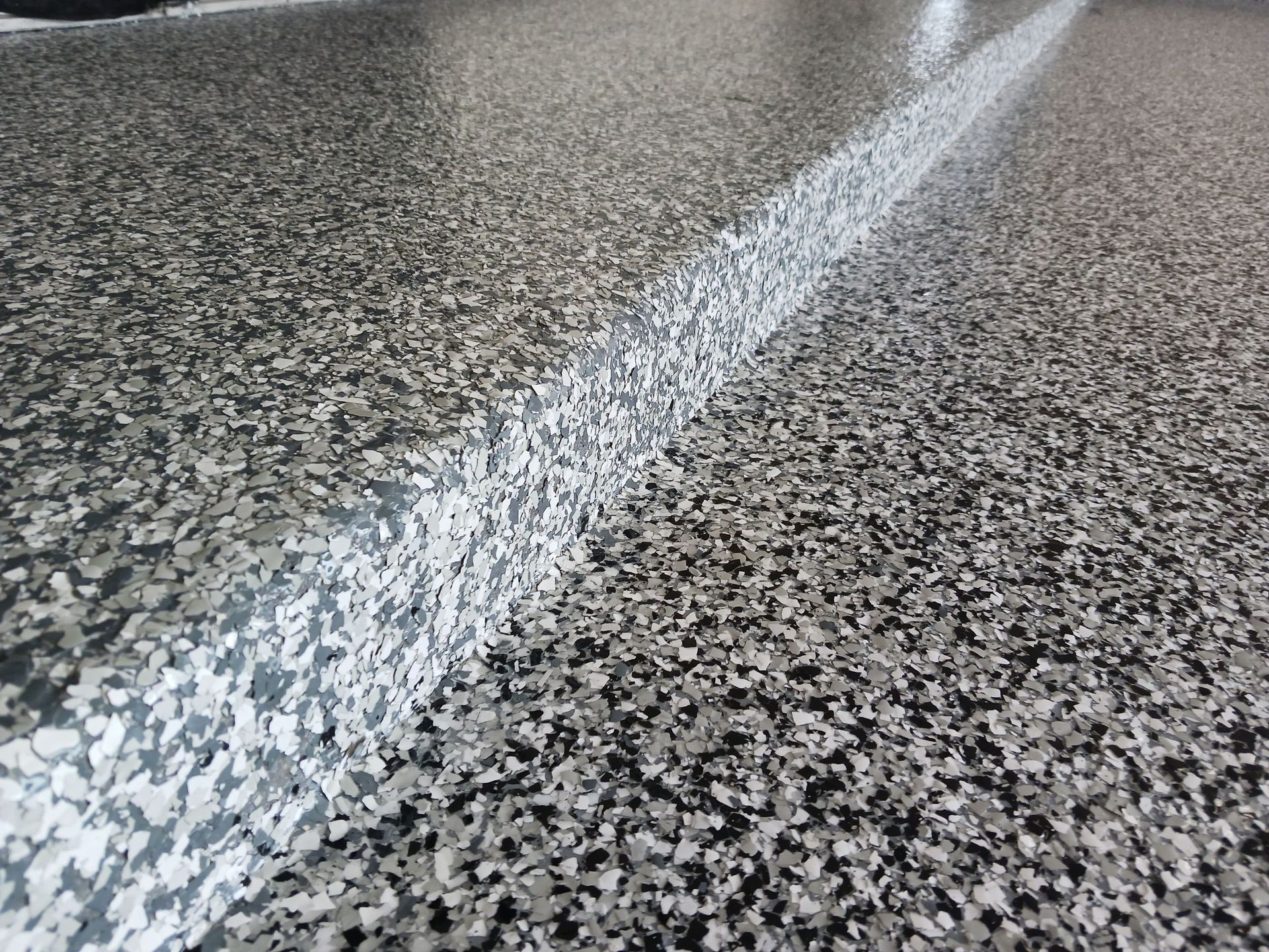 Granite-like floor with a white dividing line, reflecting light.