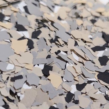 Close-up of floor flakes in shades of beige, gray, black, and white.