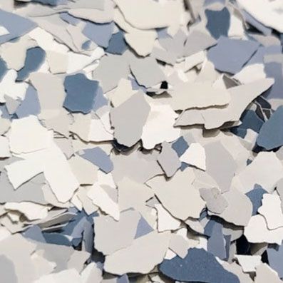 Pile of decorative floor coating flakes in shades of white, gray, and blue.